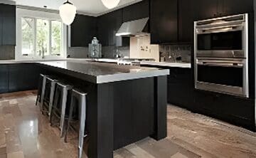 A kitchen with black cabinets and stainless steel counter tops.