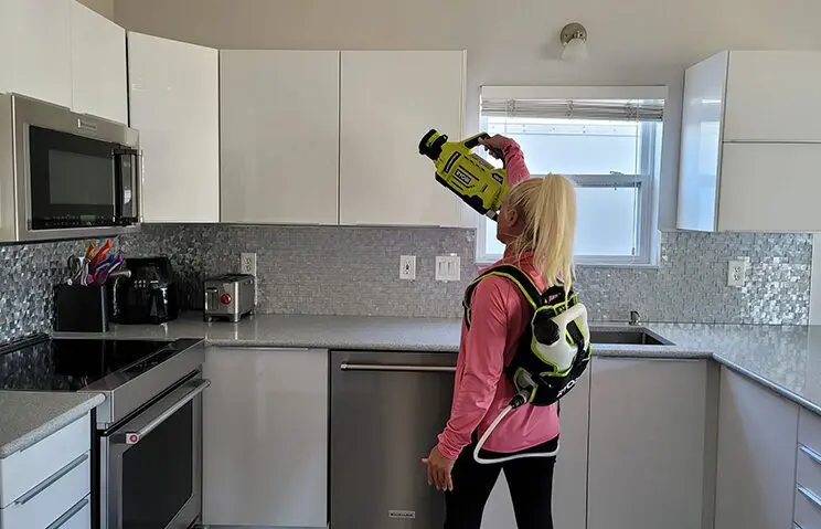 A woman in a pink shirt is holding a bottle